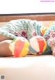 A baby laying on the floor with two colorful pillows.