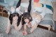 Two young women laying on the floor wearing bunny ears.