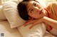 A woman laying on top of a bed next to a pillow.