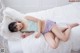 A woman laying on top of a white bed.