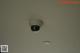 A security camera mounted on the ceiling of a room.